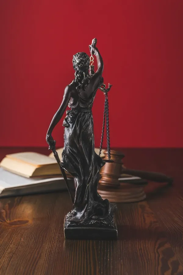 opened-juridical-books-with-lady-justice-statue-on-wooden-table-law-concept